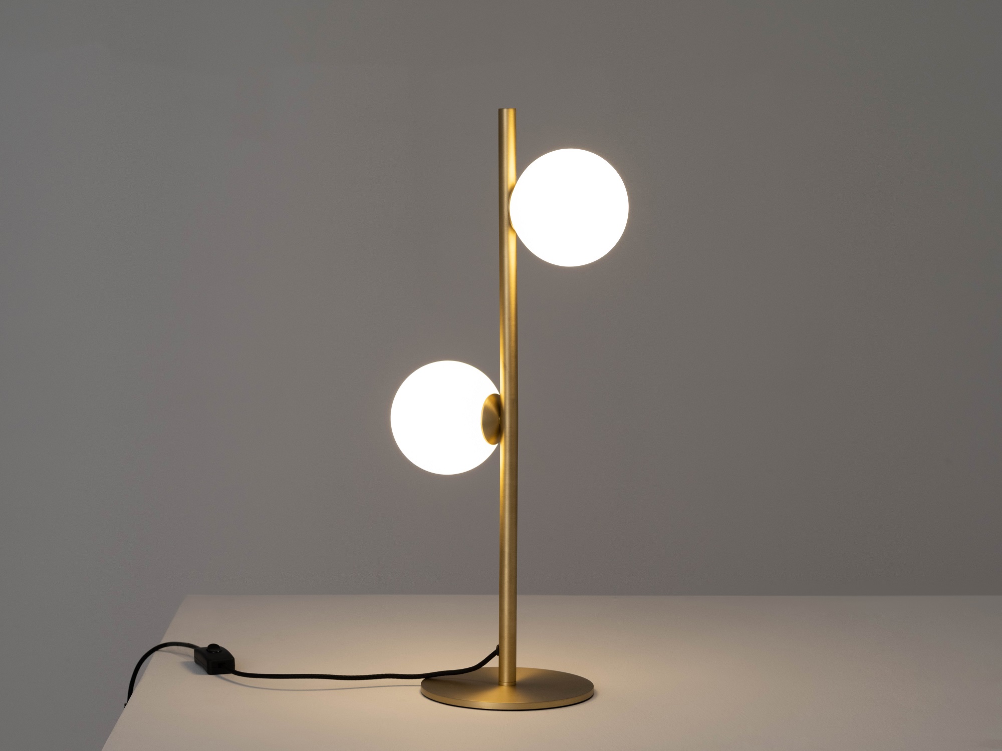 front view of the eq3 brass stem table lamp turned on